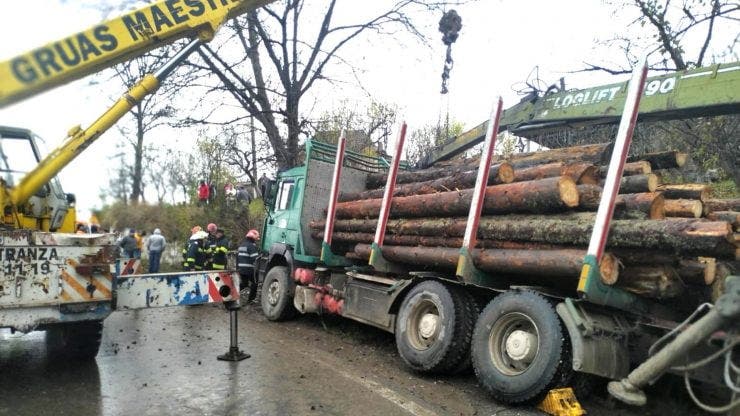 Un camion plin cu lemne s-a răsturnat peste o persoană aflată pe marginea drumului
