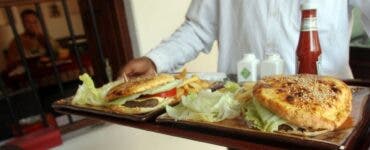 Românii cu venituri mici, trimiși să mănânce fast-food cu banii de la stat