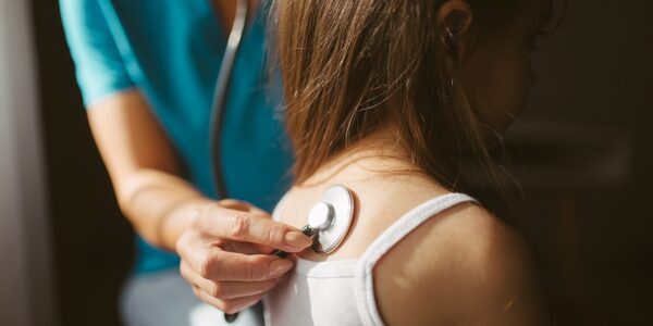 Medic de familie care consultă o pacientă cu stetoscopul