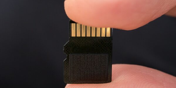 Card de memorie microSD ținut între două degete