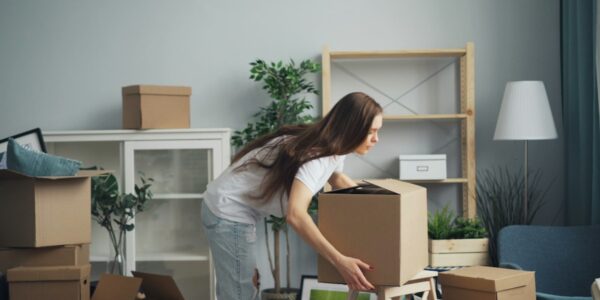Femeie care își împachetează lucrurile în cutii de carton, în sufragerie